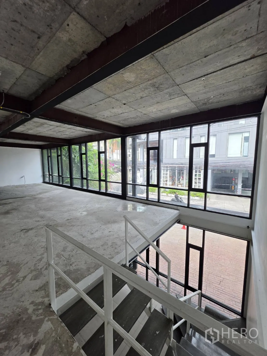 Retail Space for rent in Watthana, Bangkok - Upper level mezzanine overlooking the street through wide windows and an exposed ceiling.