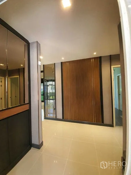 Detached House for sale in Bang Khun Thian, Bangkok - Entry foyer with wood slat feature wall and built-in mirrored cabinet.