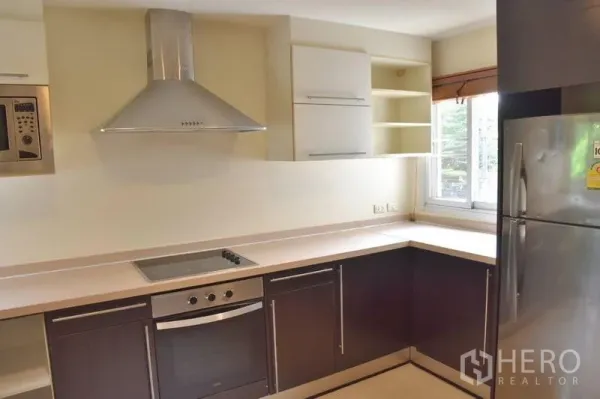 房间 出租在Sathon, Bangkok - 现代厨房角落，配不锈钢烟机和大冰箱。