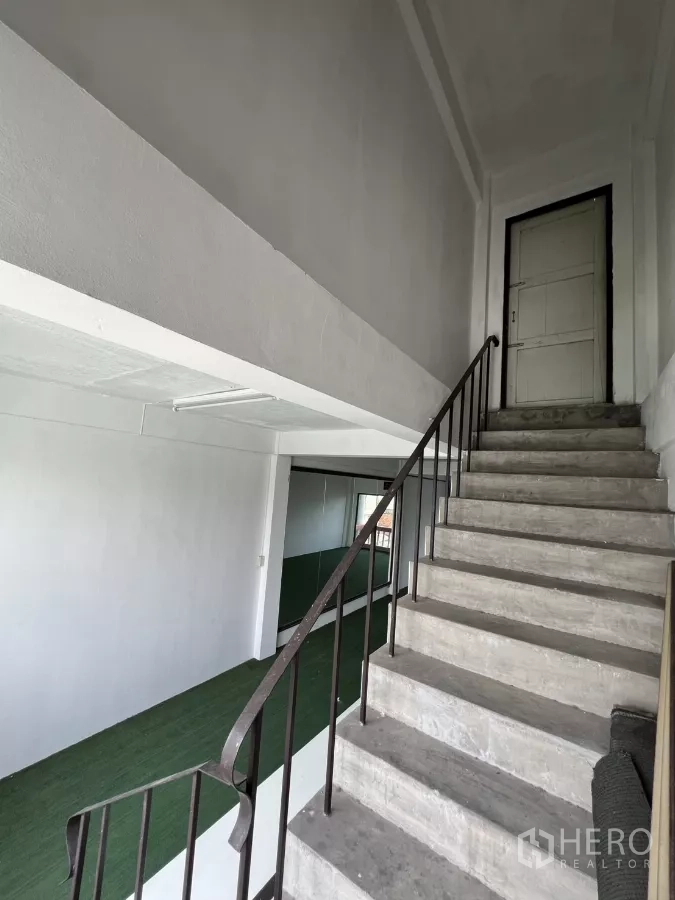 店屋 出租在Watthana, Bangkok - 混凝土楼梯通往楼上工作室，配金属栏杆。