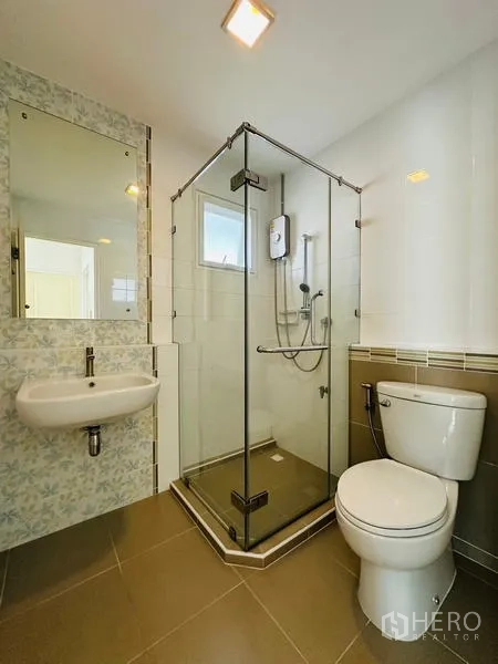 Detached House for sale in Prawet, Bangkok - Bathroom featuring a glass-enclosed shower, toilet and wall-mounted sink.
