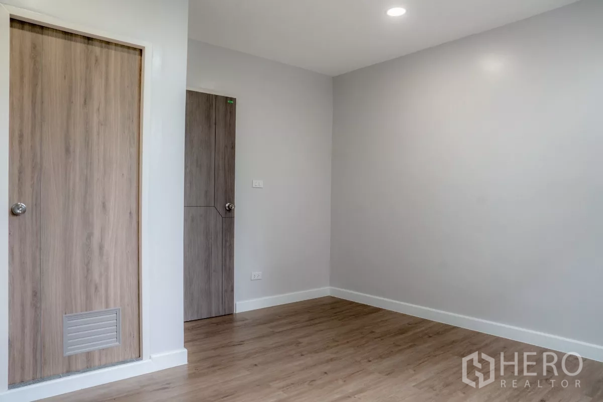 ทาวน์เฮาส์ ขายในWatthana, Bangkok - ห้องนอนพื้นไม้ลามิเนต มีประตูไม้สองบานสำหรับเก็บของและทางเข้า