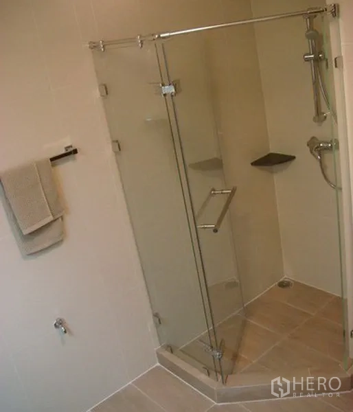 Apartment for rent in Khlong Toei, Bangkok - Walk-in glass shower enclosure with handheld showerhead and tiled walls.