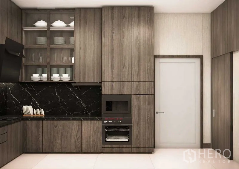 Detached House for sale in Prawet, Bangkok - Built-in kitchen storage with oven tower, glass cabinets and black countertops.