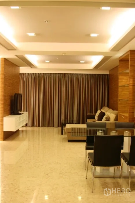 Condominium for rent in Khlong Toei, Bangkok - Spacious living room with recessed ceiling lights, polished floor and full-length curtains.