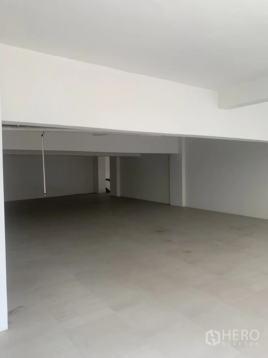零售空间 for rent in Bang Rak, Bangkok - 深进式视角的空置商铺空间，浅色地砖与白墙，待装修。