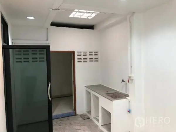 ทาวน์เฮาส์ ให้เช่าในWatthana, Bangkok - พื้นที่ครัว/ซักล้างเรียบง่าย เคาน์เตอร์คอนกรีต อ่างล้างจาน และประตูกระจกบานเลื่อน