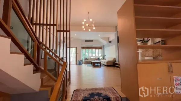 ทาวน์เฮาส์ ให้เช่าหรือขายในKhlong Toei, Bangkok - โถงทางเข้าพร้อมบันไดไม้และโคมระย้า เชื่อมสู่พื้นที่นั่งเล่นแบบเปิดโล่ง