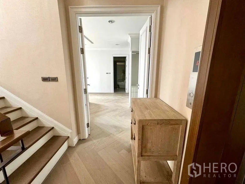 ทาวน์เฮาส์ ให้เช่าในWatthana, Bangkok - โถงบันไดสว่างพื้นปาร์เกต์ลายก้างปลา ประตูเชื่อมถึงห้อง ข้างแผงลิฟต์ส่วนตัว.