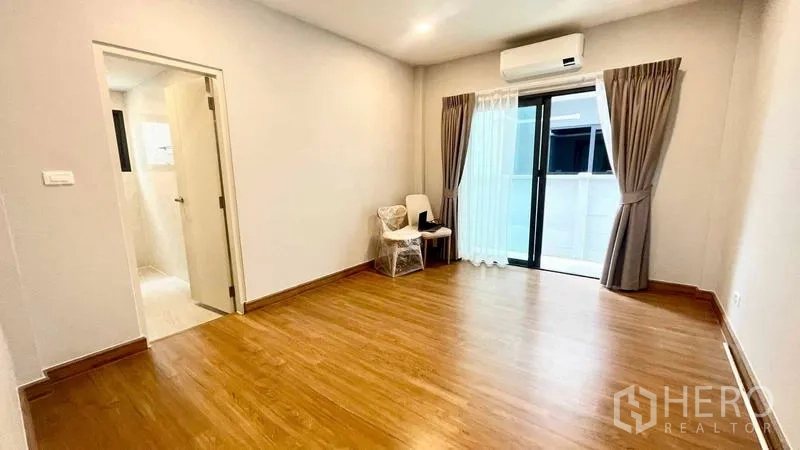 Detached House for rent in Bang Phli, Samut Prakan - Guest bedroom with ensuite, wooden floors, balcony access and air conditioner