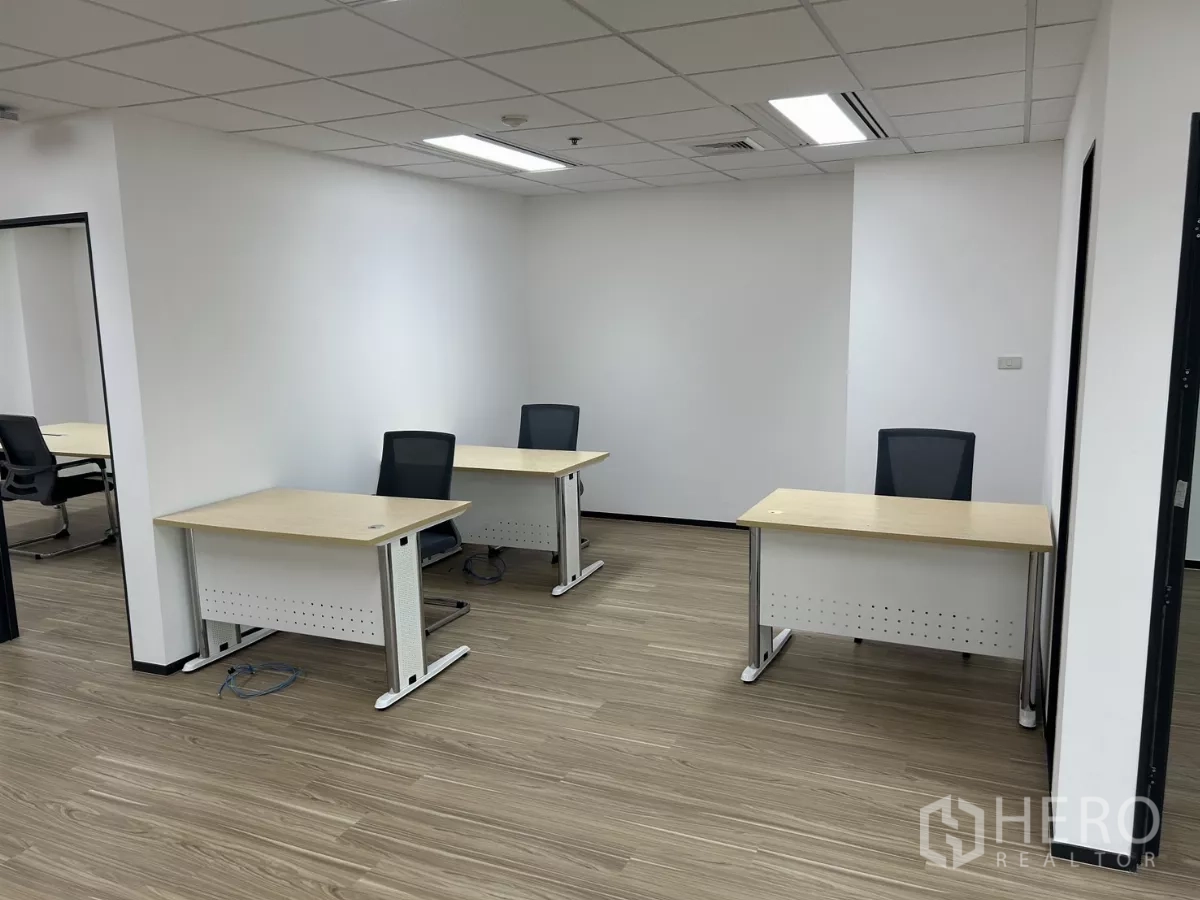 สำนักงาน ให้เช่า - พื้นที่ทำงานแบ่งสัดส่วน มีโต๊ะทำงานและเก้าอี้สามชุด ใต้ไฟฝังฝ้าและพื้นลายไม้