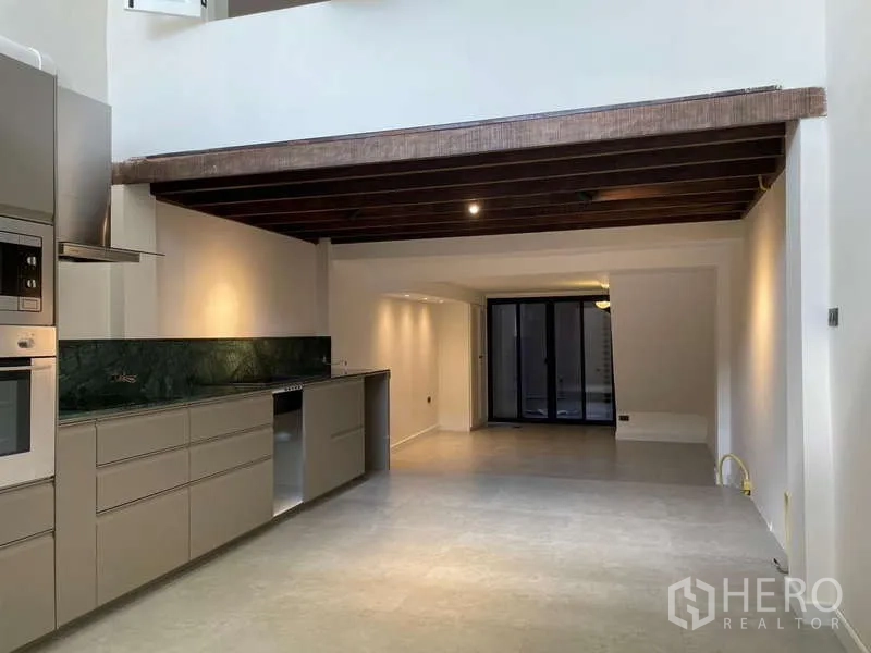 สำนักงานที่บ้าน ให้เช่าในWatthana, Bangkok - ครัวเปิดสมัยใหม่ ตู้บิลท์อิน ผนังหินสีเขียว เพดานคานไม้และประตูกระจกบานเลื่อน.