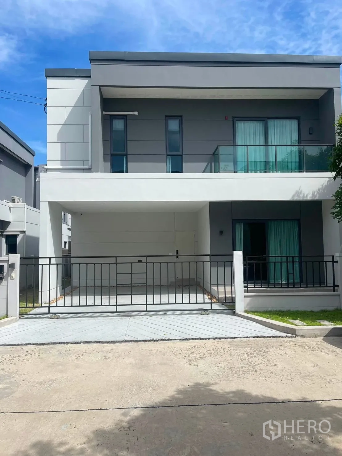 独栋房屋 for rent in Bang Phli, Samut Prakan - 现代两层外立面，带阳台、滑动大门、车道与小草坪。