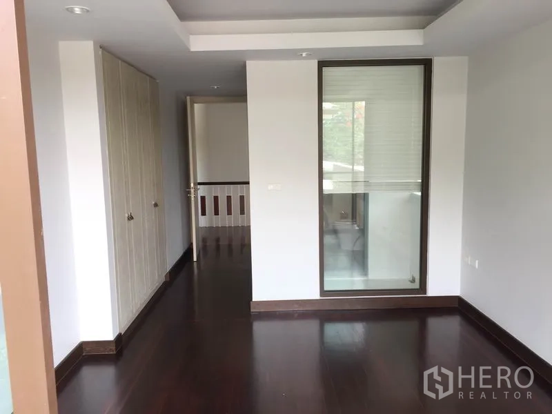 Detached House for rent in Sathon, Bangkok - Upper-floor room with built-in wardrobes and a door to a small balcony