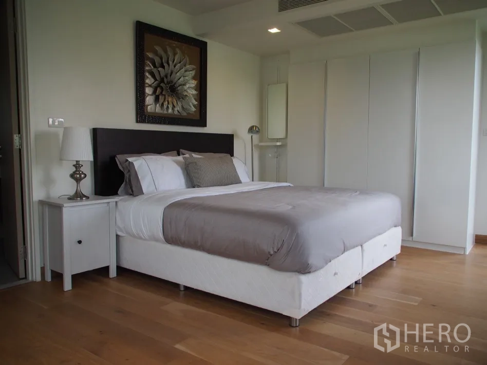 คอนโด for rent or sale in Watthana, Bangkok - ห้องนอนกว้างพร้อมเตียงขนาดใหญ่ ตู้เสื้อผ้า และพื้นไม้