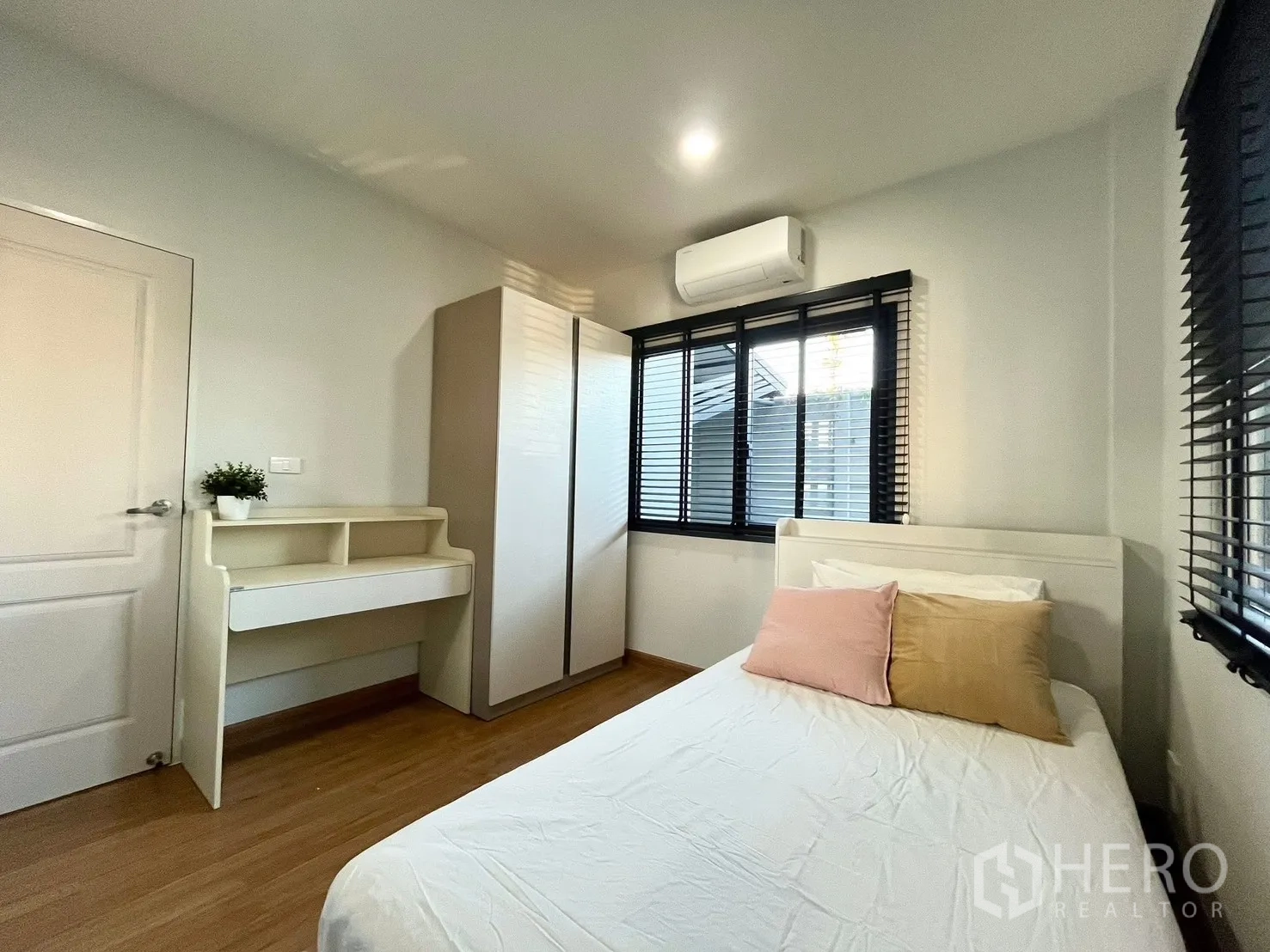 Detached House for rent in Bang Phli, Samut Prakan - Bright secondary bedroom with double bed, wardrobe, desk and corner windows.