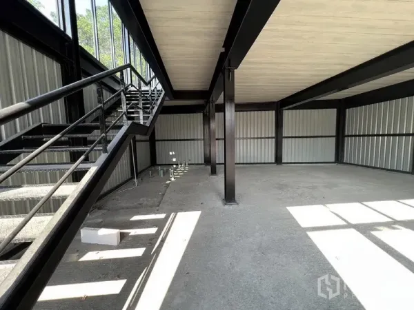 零售空间 出租在Bang Na, Bangkok - 工业风楼梯通往夹层，上下层采光充足的商铺内部。