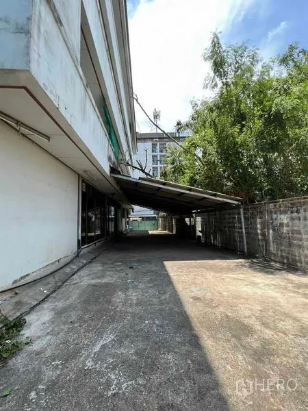 Factory for rent in Bang Na, Bangkok - Side driveway with a covered loading bay alongside the factory.