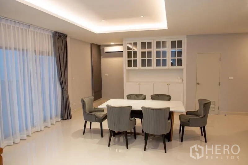 Detached House for rent in Bang Phli, Samut Prakan - Dining area with six upholstered chairs and glass-front cabinets.