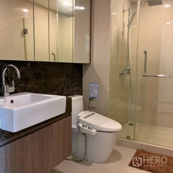 คอนโด ให้เช่า - ห้องน้ำที่สองมีตู้กระจก อ่างล้างหน้า โถสุขภัณฑ์อัตโนมัติ และห้องอาบน้ำกระจก