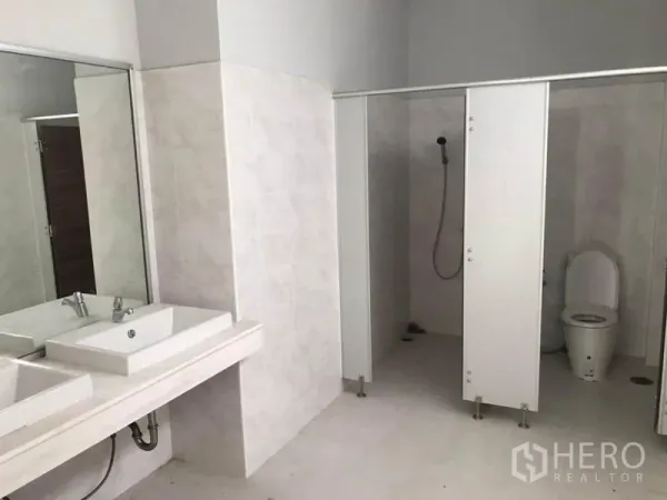 Warehouse for rent in Sai Noi, Nonthaburi - Clean restroom with twin basins, shower area and toilet cubicles inside the warehouse.