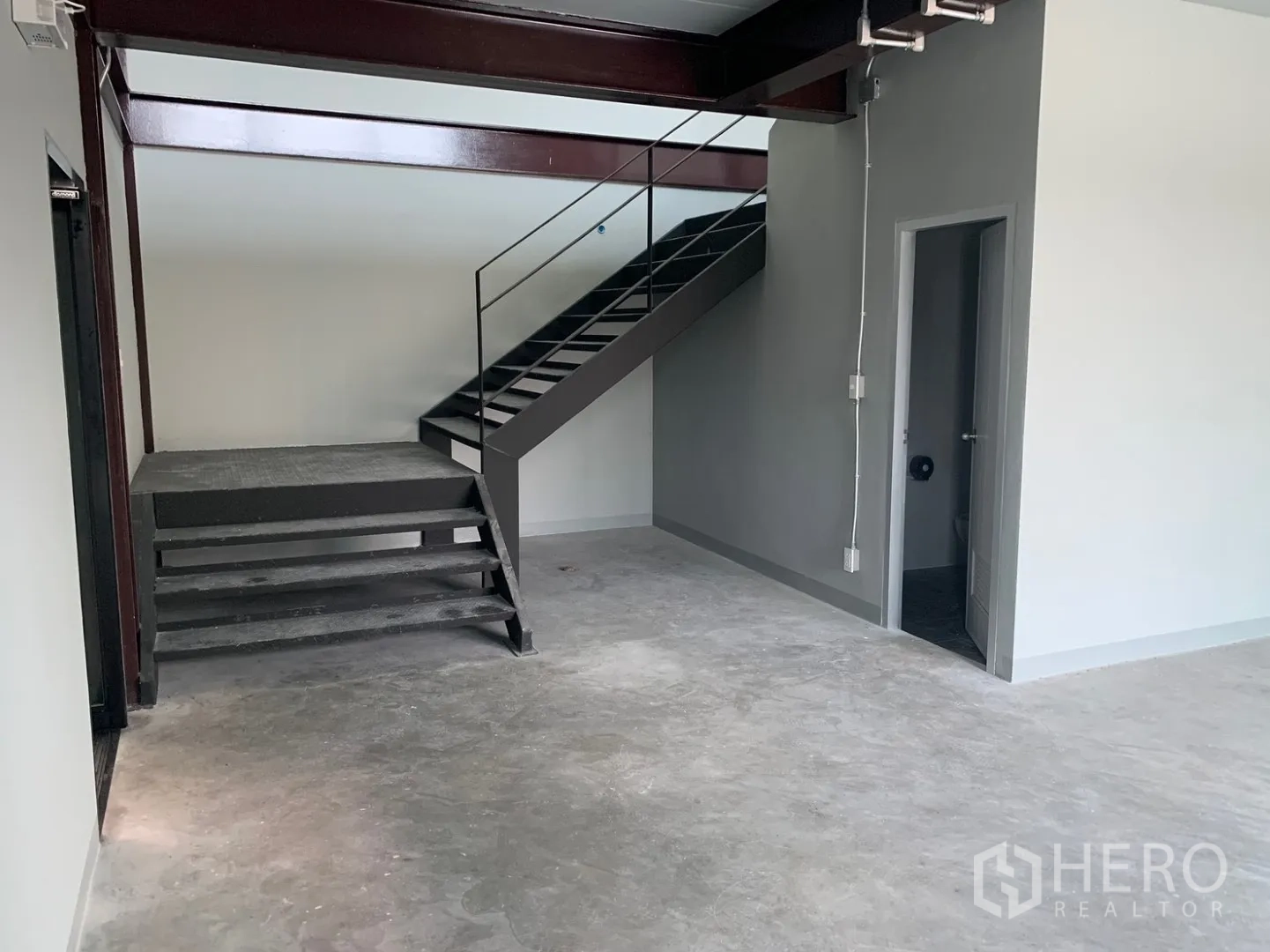 โกดัง for rent in Bang Phli, Samut Prakan - พื้นที่ชั้นล่างมีบันไดเหล็ก พื้นคอนกรีต และประตูเข้าห้องน้ำ