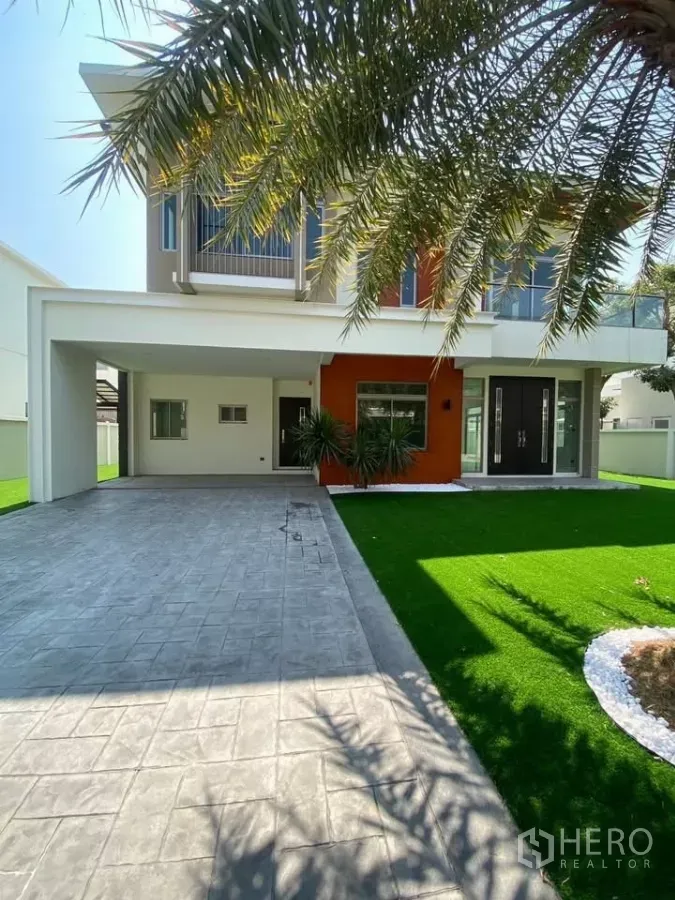 独立式住宅 出租在Bang Phli, Samut Prakan - 现代两层独栋别墅外观，带车棚与人工草坪