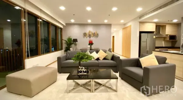 คอนโด ให้เช่าหรือขายในKhlong Toei, Bangkok - ห้องรับแขกสว่างไสว กระจกเต็มบาน เห็นวิวเมืองยามค่ำ และชุดนั่งเล่นสมัยใหม่