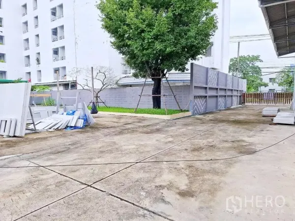 คลังสินค้า ให้เช่าในBang Kapi, Bangkok - ลานคอนกรีตกว้างข้างโกดัง มีรั้วรอบและต้นไม้ใหญ่ เหมาะจอดรถและโหลดสินค้า