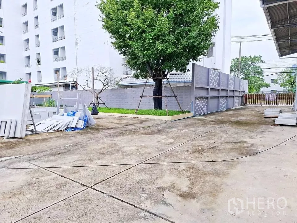 คลังสินค้า ให้เช่าในBang Kapi, Bangkok - ลานคอนกรีตกว้างข้างโกดัง มีรั้วรอบและต้นไม้ใหญ่ เหมาะจอดรถและโหลดสินค้า