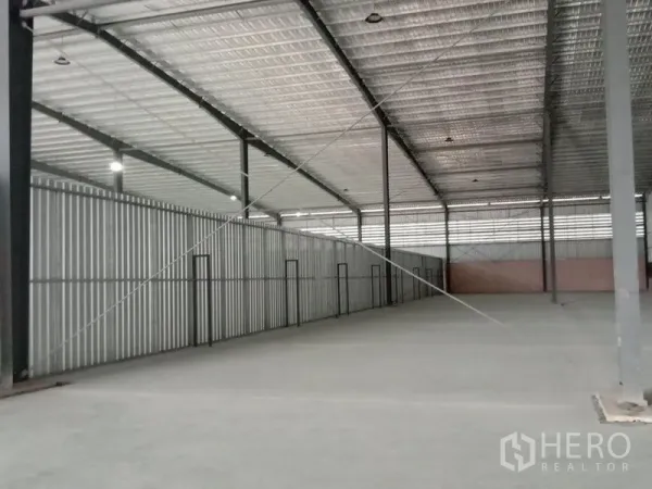 Factory for rent in Ban Phaeo, Samut Sakhon - Spacious factory interior with high steel trusses, insulated roof and durable concrete floor.