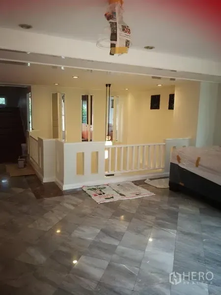 Townhouse for rent or sale in Watthana, Bangkok - Spacious split-level living area with marble flooring and recessed lights.