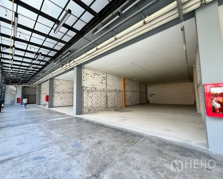 Retail Space for rent - Covered arcade frontage with wide shop opening, visible fire hose cabinet and open-plan retail bay.
