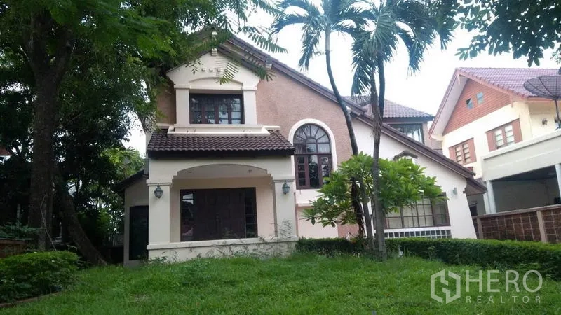 独立式住宅 出租 - 房屋正立面，拱形窗与草坪、棕榈树景观。