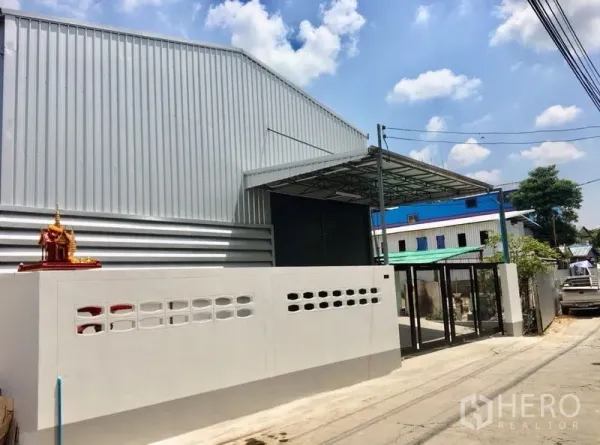 คลังสินค้า ให้เช่าในDin Daeng, Bangkok - มุมมองจากถนน เห็นด้านหน้าโกดัง ประตูเลื่อนสีดำและกำแพงรั้ว