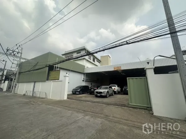 คลังสินค้า ให้เช่าในYan Nawa, Bangkok - มุมมองจากถนนของโกดังยานนาวาพร้อมรั้วและผนังเมทัลชีทสีเขียว มีที่จอดรถด้านหน้า