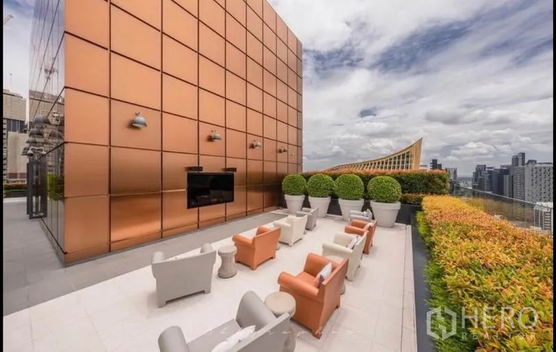 公寓 出租或出售在Watthana, Bangkok - 屋顶露台座位区，铜色立面与户外电视。