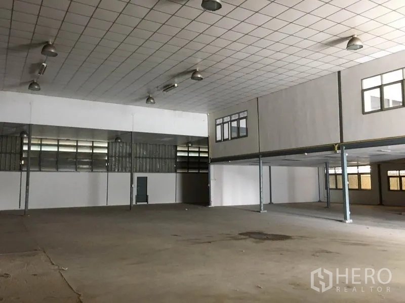 货栈 出租在Prawet, Bangkok - 开阔的仓库地面，混凝土地坪，临夹层办公室与多处出入口。