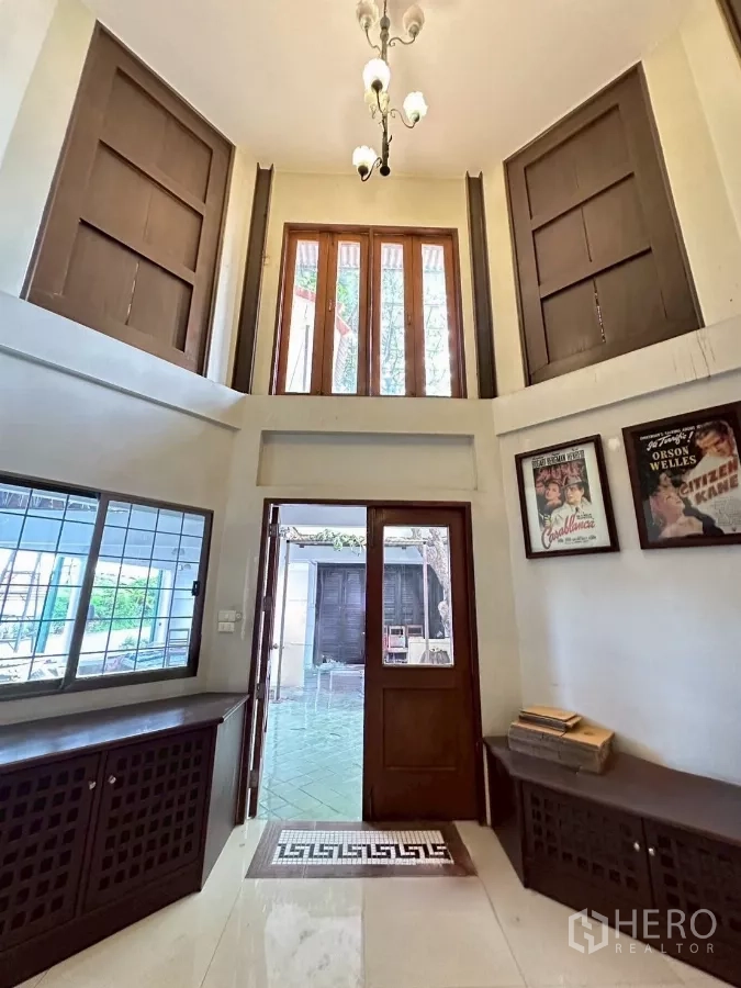 สำนักงานที่บ้าน ให้เช่าในLat Phrao, Bangkok - โถงทางเข้าเพดานสูงสองชั้น ประตูไม้ หน้าต่างสูง และโคมระย้า