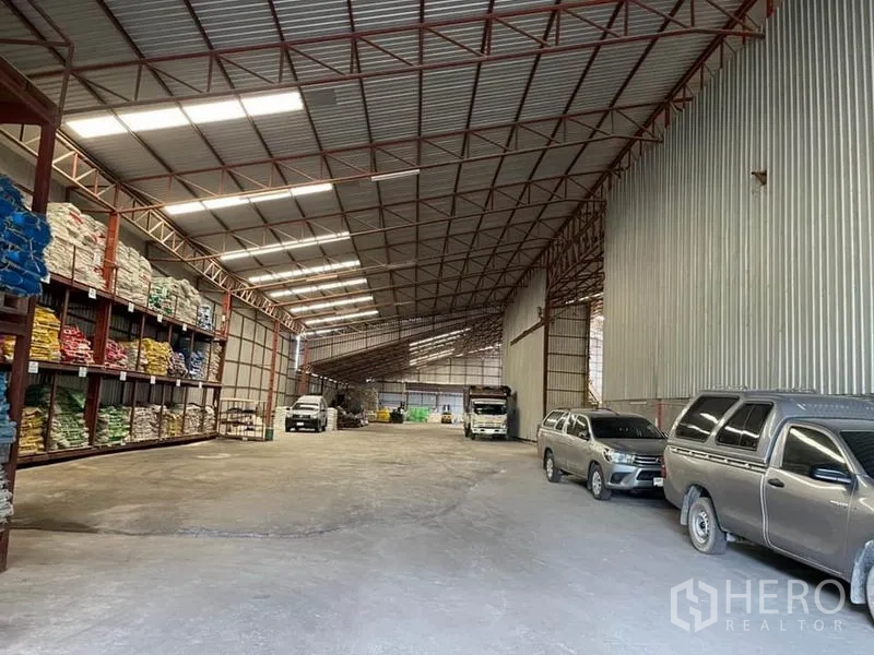 货栈 出售在Lam Luk Ka, Pathum Thani - 宽阔存储通道，带托盘货架、天窗采光，可容纳卡车。