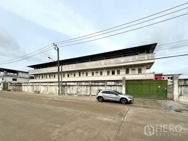 Warehouse for rent in Bang Khun Thian, Bangkok - Long exterior elevation of the warehouse compound along a quiet industrial street.
