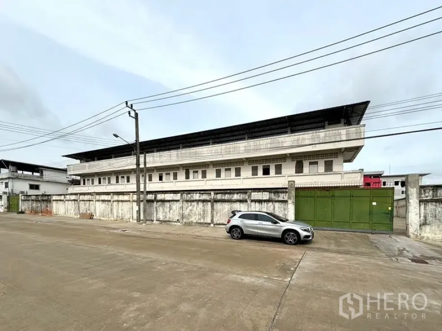 Warehouse for rent in Bang Khun Thian, Bangkok - Long exterior elevation of the warehouse compound along a quiet industrial street.