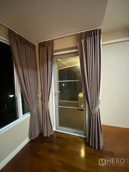 Detached House for rent in Prawet, Bangkok - Sliding door with full curtains leading to a covered balcony area.