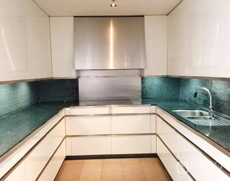 公寓 出租或出售在Sathon, Bangkok - 现代U形厨房，白色亮面柜体与石材台面。