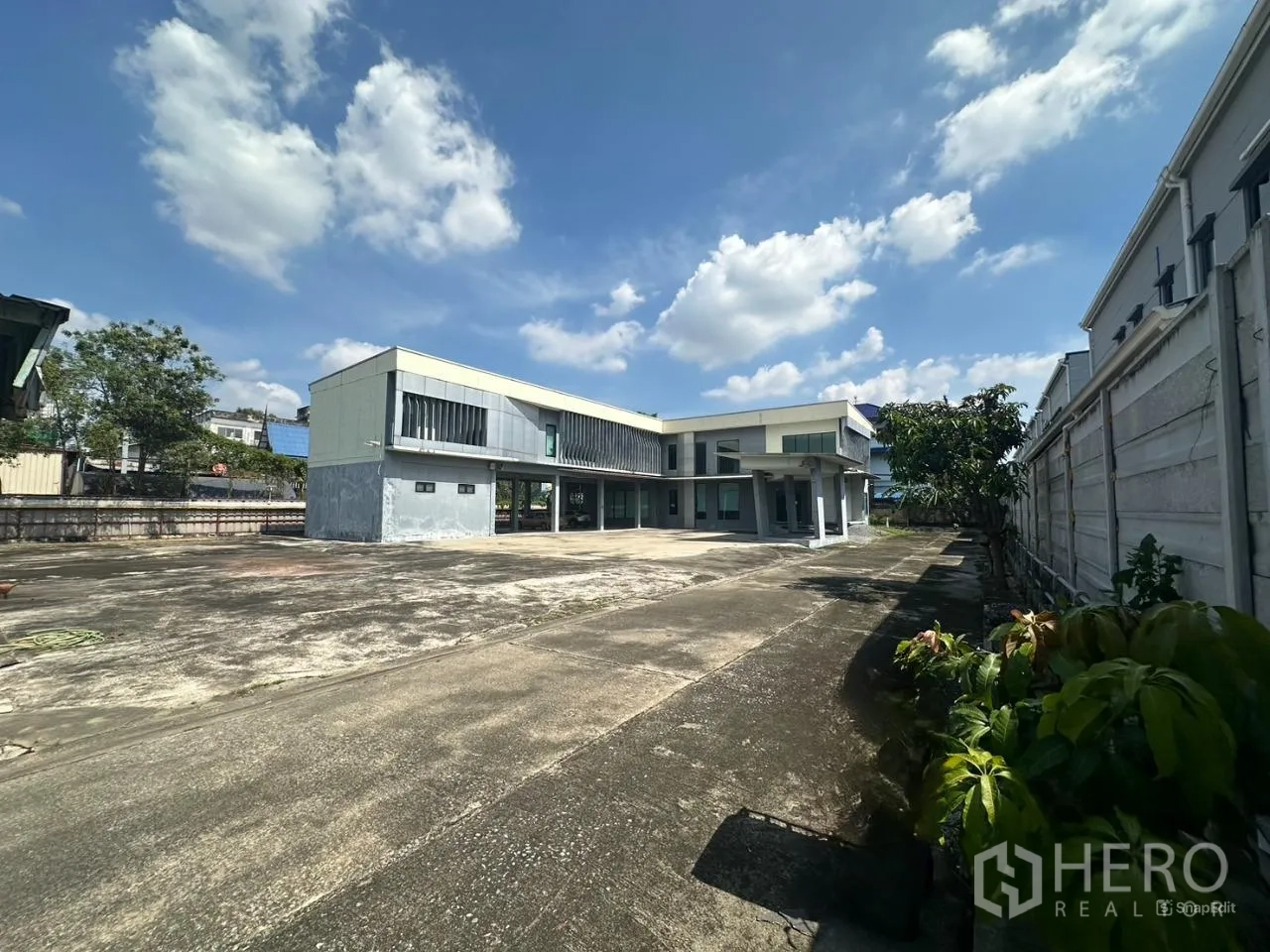 Home Office for rent in Prawet, Bangkok - Wide view of a two-storey modern home office with a large paved forecourt and perimeter wall in Prawet, Bangkok.