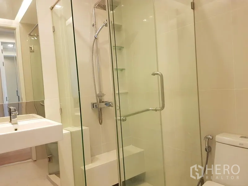 คอนโด ให้เช่าในChatuchak, Bangkok - ห้องน้ำสะอาดพร้อมตู้ชาวเวอร์กระจก หัวฝักบัวเรนชาวเวอร์ กระเบื้องสีขาว และสุขภัณฑ์ทันสมัย
