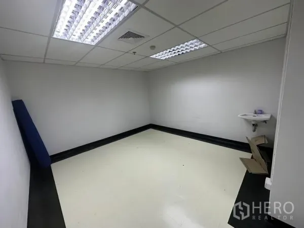Office Space for rent - Compact internal room with ceiling lights and a wall-mounted sink, ideal for pantry or storage in the Bangkok office.