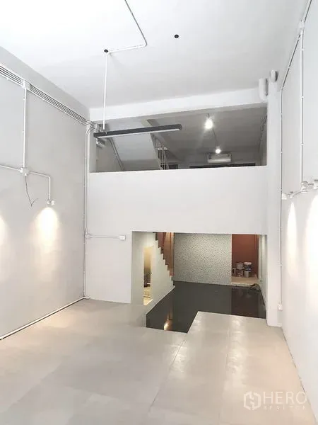 อาคารพาณิชย์ ให้เช่าในPhra Khanong, Bangkok - ชั้นล่างแบบโอเพ่นสเปซ มีชั้นลอย บันได และไฟส่องผนัง ในอาคารพาณิชย์รีโนเวต