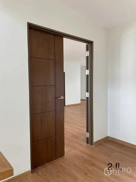 Home Office for rent or sale in Bang Phli, Samut Prakan - Wooden door and corridor leading to upper-floor workspace with clean white walls.