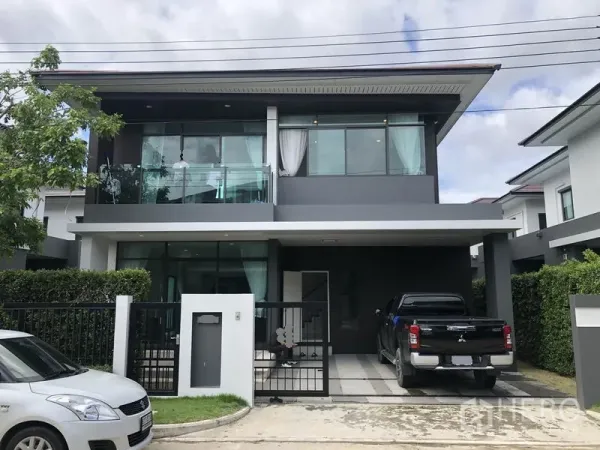 Detached House for rent or sale in Bang Kapi, Bangkok - Modern two-storey detached house with balcony, gate and a covered two-car carport in a leafy estate.